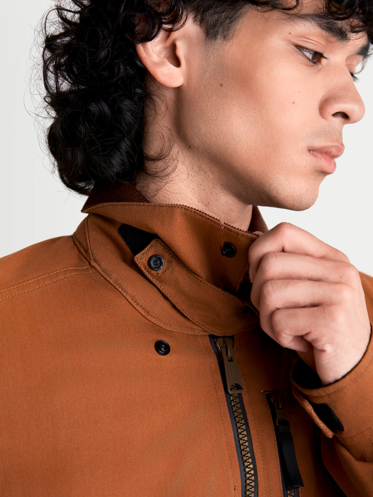 Alpinestars Mustang WP jakke, urban herremotorcykeljakke i mørk rust og mørkebrun, nærbillede af stretch-twill-krave og lynlåskonstruktion båret af mandlig model