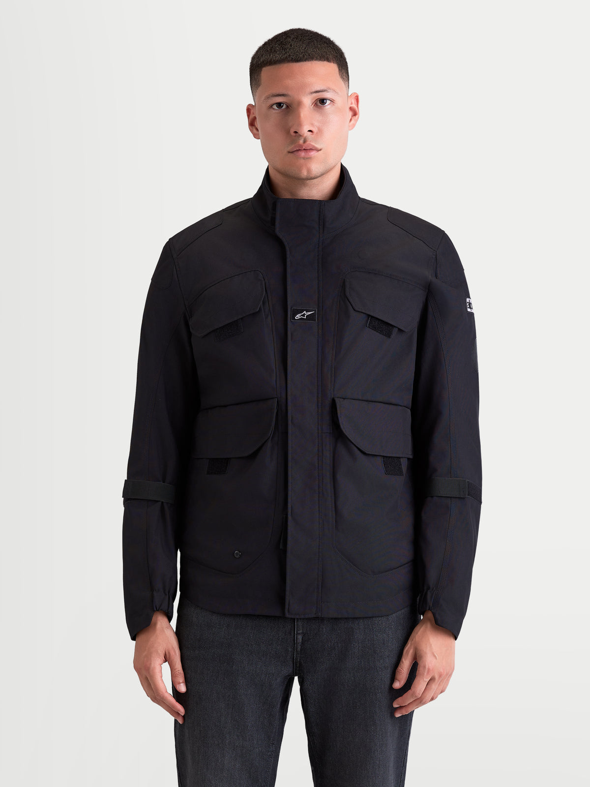 Altan Drystar® Jacket, men's urban contemporary waterproof motorcycle field jacket in black, front view on a model showing the matte polyfabric construction, dual-entry cargo pockets, and ergonomic warm collar.