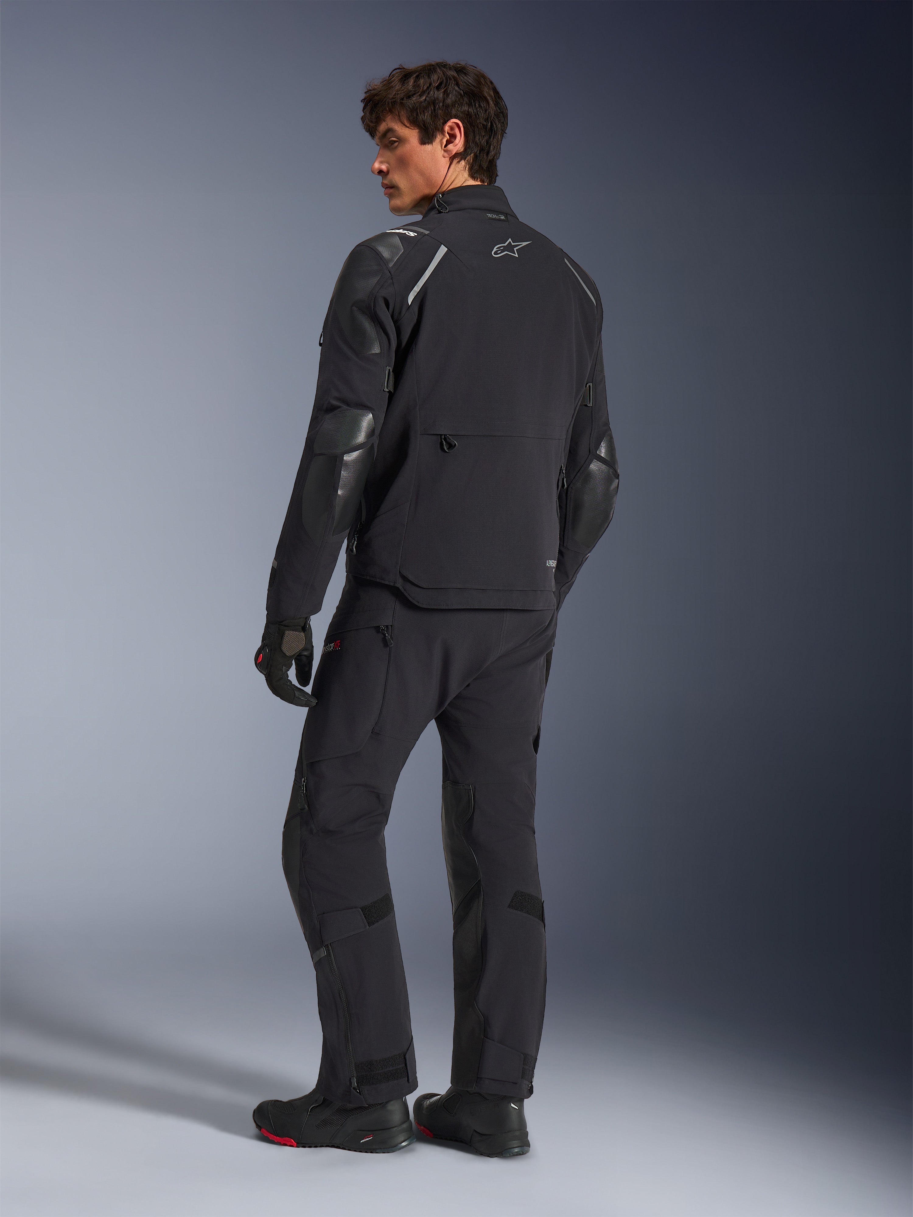 Alpinestars Andes Pro Drystar® XF jakke, adventure motorcykeljakke, sort, set bagfra med matchende bukser og støvler, med forstærkede paneler og sølvstjerne-logo, teknisk køreudstyr til al slags vejr