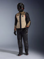 Alpinestars Andes Pro Drystar® XF-jakke i Walnut Aluminum, adventure-motorcykeljakke kombineret med matchende sorte bukser, en sort adventure-hjelm med briller og sorte støvler, med tan-farvede og sorte paneler med røde detaljer.