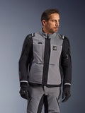 Alpinestars Andes Pro Drystar® XF-jakke i mørkegrå og sort, adventure-køreudstyr, båret af en mand med matchende grå bukser og sorte handsker, med en 3-lags lamineret skal, praktiske lommer og 'Terra'-logo på brystet