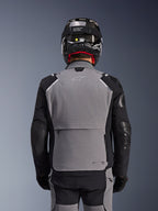 Alpinestars Andes Pro Drystar® XF jakke, mørkegrå og sort, set bagfra med stor baglomme og Tech-Air branding, båret af en kører med sort hjelm og matchende kørebukser, professionelt adventure touring-udstyr