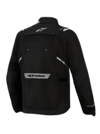 Alpinestars Cusco Drystar®-jakke, sort, set bagfra, med hvidt stjernelogo øverst på ryggen, reflekterende Alpinestars-navnetræk nederst på ryggen, stort ventilationspanel med lynlås og holdbar tekstilkonstruktion til adventure touring