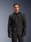 Alpinestars Cusco Drystar® jakke, sort motorcykeljakke, båret af en model med matchende sorte handsker og bukser, teknisk tekstilkonstruktion med hvide Alpinestars-logoer, designet til road adventure touring