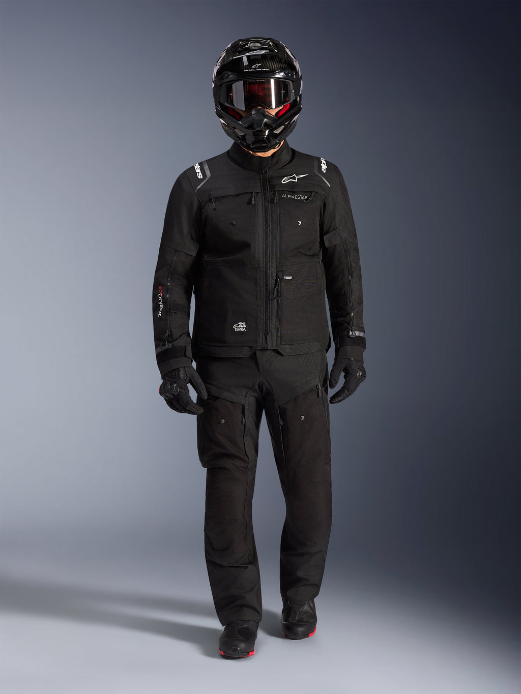 Alpinestars Cusco Drystar® jakke, sort adventure motorcykel touring-jakke, båret med matchende sorte bukser, full-face hjelm, handsker og støvler, med teknisk ripstop-konstruktion og hvidt Alpinestars-branding