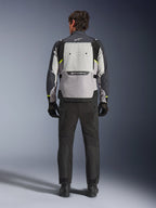 Set bagfra af en motorcyklist iført Alpinestars Cusco Drystar®-jakke i Ice Gray, Mid Gray og Deep Gray, kombineret med sorte motorcykelbukser og handsker, hvilket fremhæver det store ventilationspanel på ryggen og Alpinestars-branding