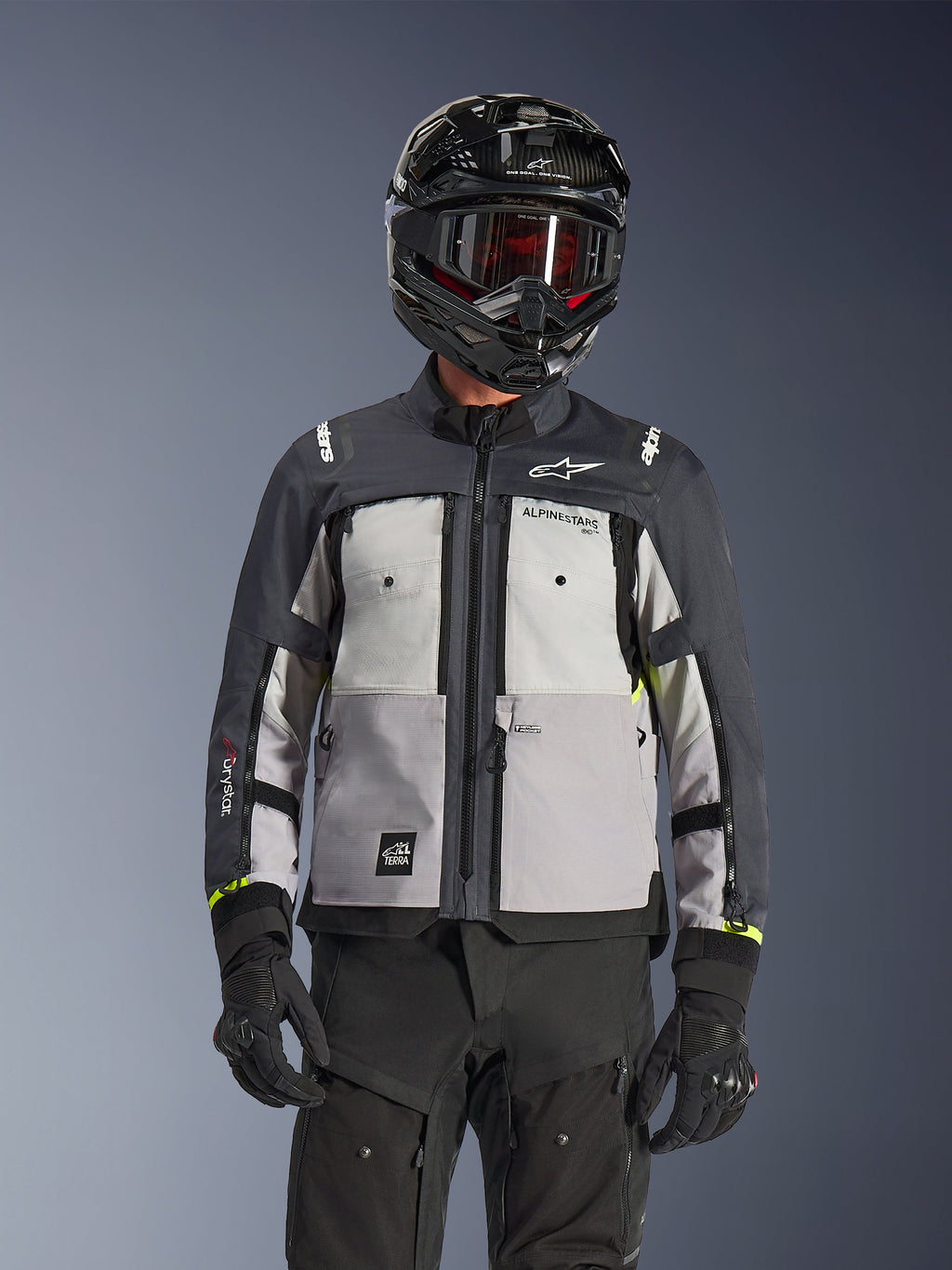Alpinestars Cusco Drystar® jakke, adventure touring-jakke, Ice Gray, Mid Gray og Deep Gray, med grå paneler i flere nuancer, brystventilation med lynlås og Alpinestars-branding, båret af en kører med sort hjelm og goggles.