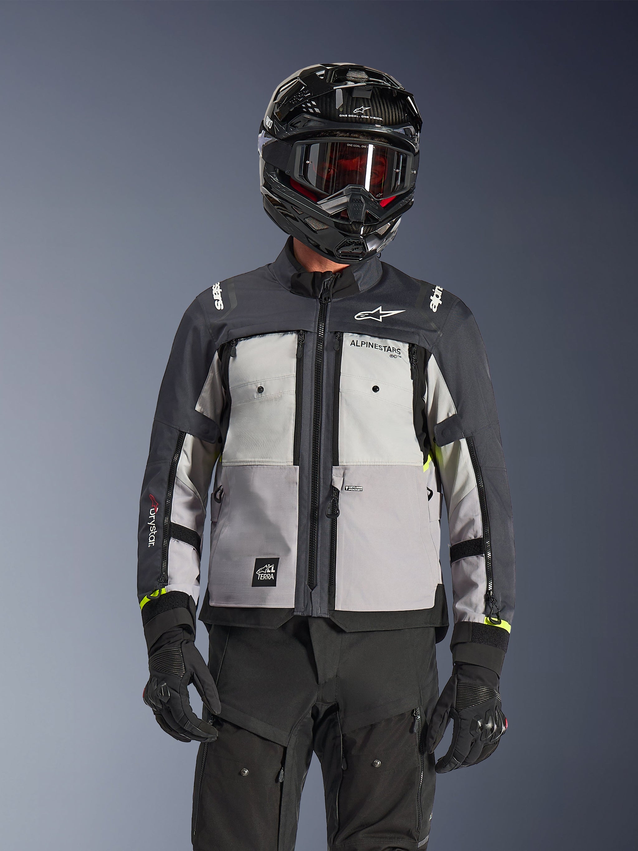 Alpinestars Cusco Drystar® Jacket, Adventure Touring Jacket, Ice Gray Mid Gray and Deep Gray, featuring multi-tonal gray panels, zippered chest vents, and Alpinestars branding, worn by a rider with a black helmet and goggles.