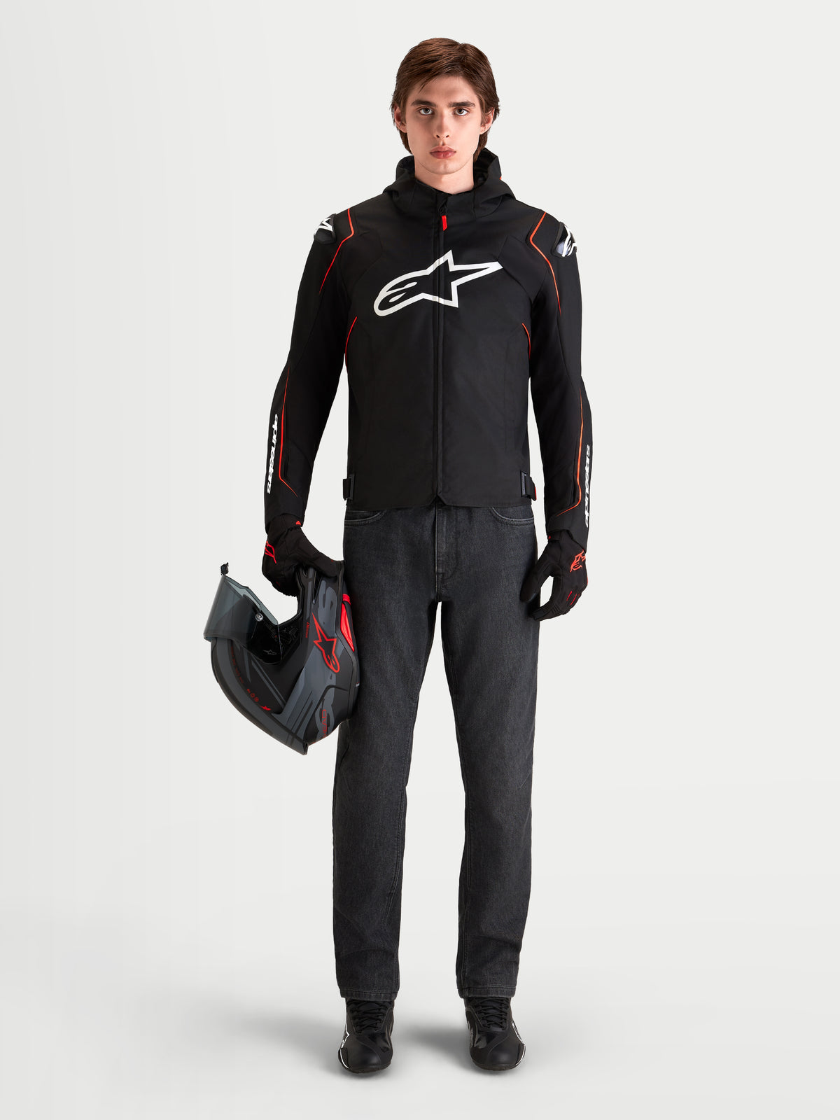 Alpinestars Zaca V2 Waterproof Jacket, Men's Black and Red Fluo motorcycle sport jacket with DFS shoulder armor and integrated hood, worn by a model holding a helmet