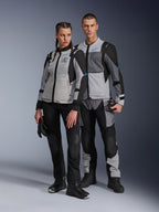 Mand og kvinde iført Alpinestars Stella ST-2 Air-jakker og matchende tekniske bukser, Ice Gray og sort farvekombination med blå detaljer, mesh-ventilation, 'ALPINESTARS EXPLORATION EQUIPMENT'-branding, studie-parbillede