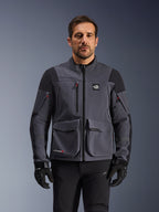 Alpinestars Maxdura Drystar®XF Laminated Armored Shell, mørkegrå og sort adventure-motorcykeljakke, set forfra på model, med store cargo-lommer, 'All Terra'-logo på brystet og ventilationslynlåse, kombineret med sorte kørehandsker og bukser.