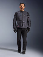Maxdura Drystar®XF Laminated Armored Shell, motorcykeljakke, Deep Gray Black, båret af en model med sorte bukser og handsker, med store cargo-lommer, røde lynlåsdetaljer og All Terra-branding, teknisk adventure-køreudstyr