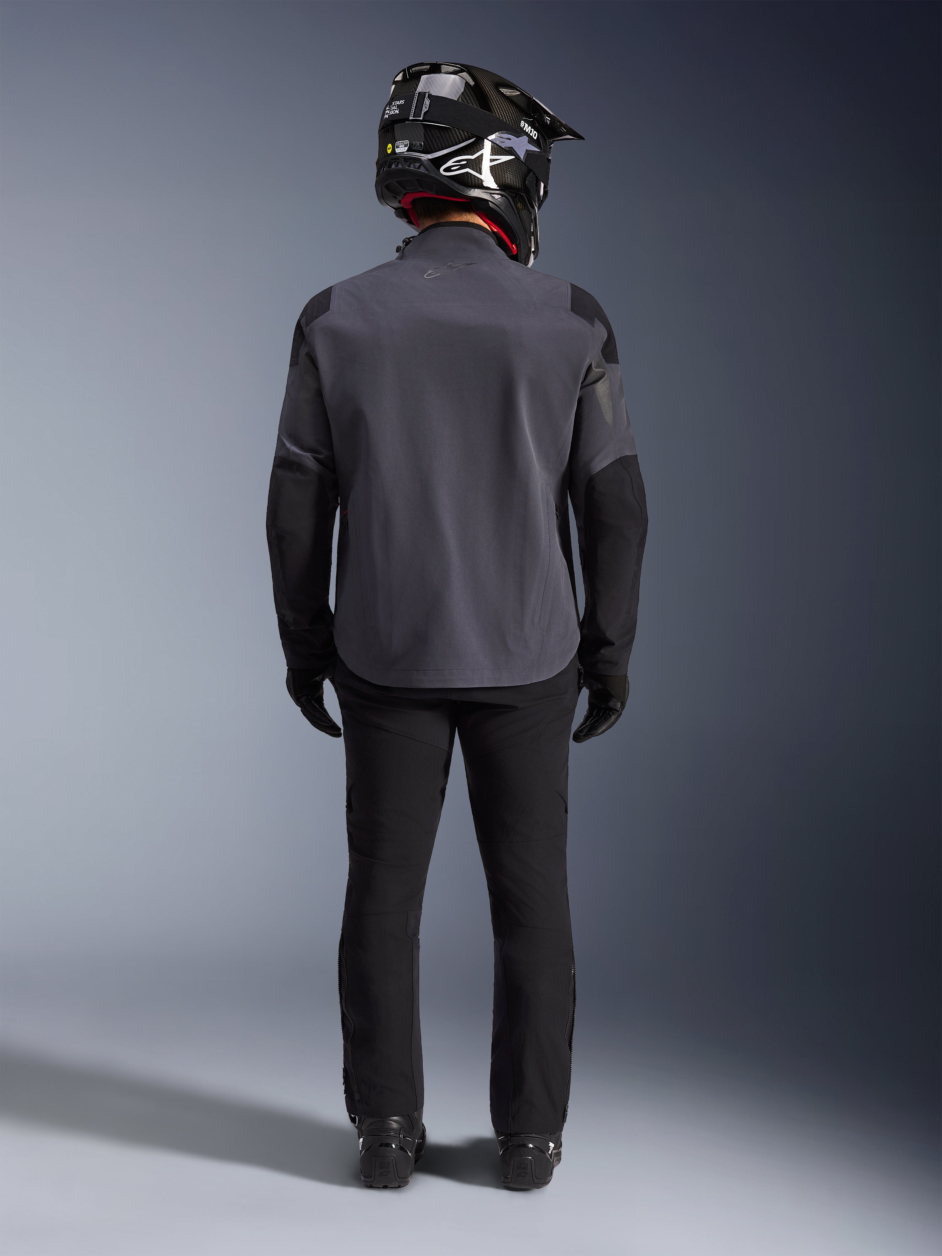 Alpinestars Maxdura Drystar®XF Laminated Armored Shell, Deep Gray Black, rygvisning i fuld længde, teknisk adventure-jakke med forstærkede paneler, båret med sorte kørebukser, handsker og en sort og hvid off-road-hjelm, koordineret dual-sport-udstyrssæt