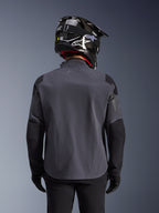 Alpinestars Maxdura Drystar®XF Laminated Armored Shell, adventure motorcykeljakke, Deep Gray Black, set bagfra med fokus på den tekniske tekstilkonstruktion og forstærkede paneler, båret med sort kulfiberhjelm, sorte kørebukser og handsker