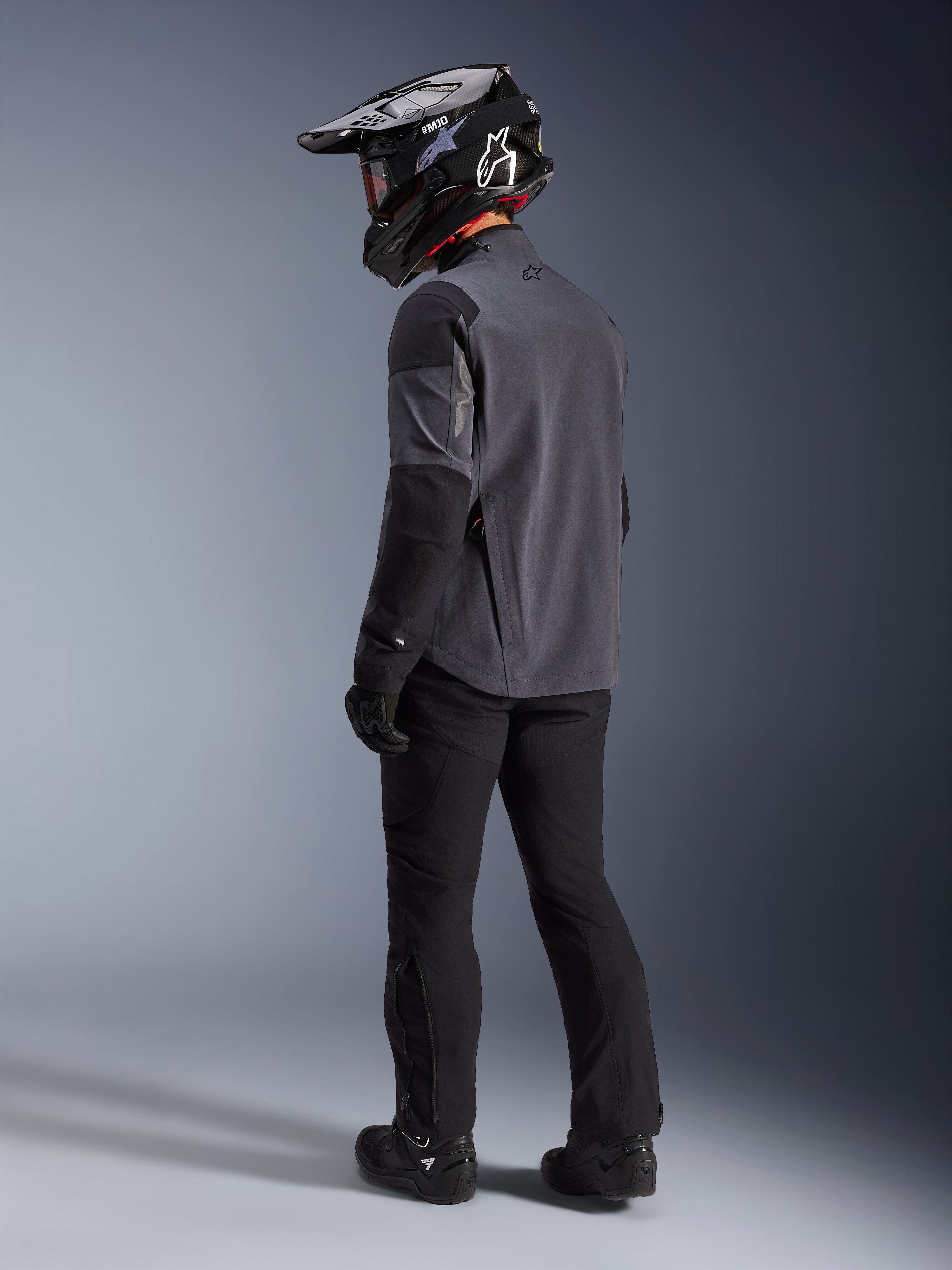 Alpinestars Maxdura Drystar®XF Laminated Armored Shell i Deep Gray Black, adventure-rytter set bagfra, komplet udstyrssæt med sorte motorcykelbukser, sort motocrosshjelm og sorte off-road støvler, teknisk køreudstyr til al slags vejr og dual-sport performance.