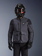 Alpinestars Maxdura Drystar®XF Laminated Armored Shell, motorcykeljakke, mørkegrå og sort, bæres af en kører med sort hjelm, briller og handsker, med store tekniske cargo-lommer og ALL TERRA-branding, adventure touring-udstyr