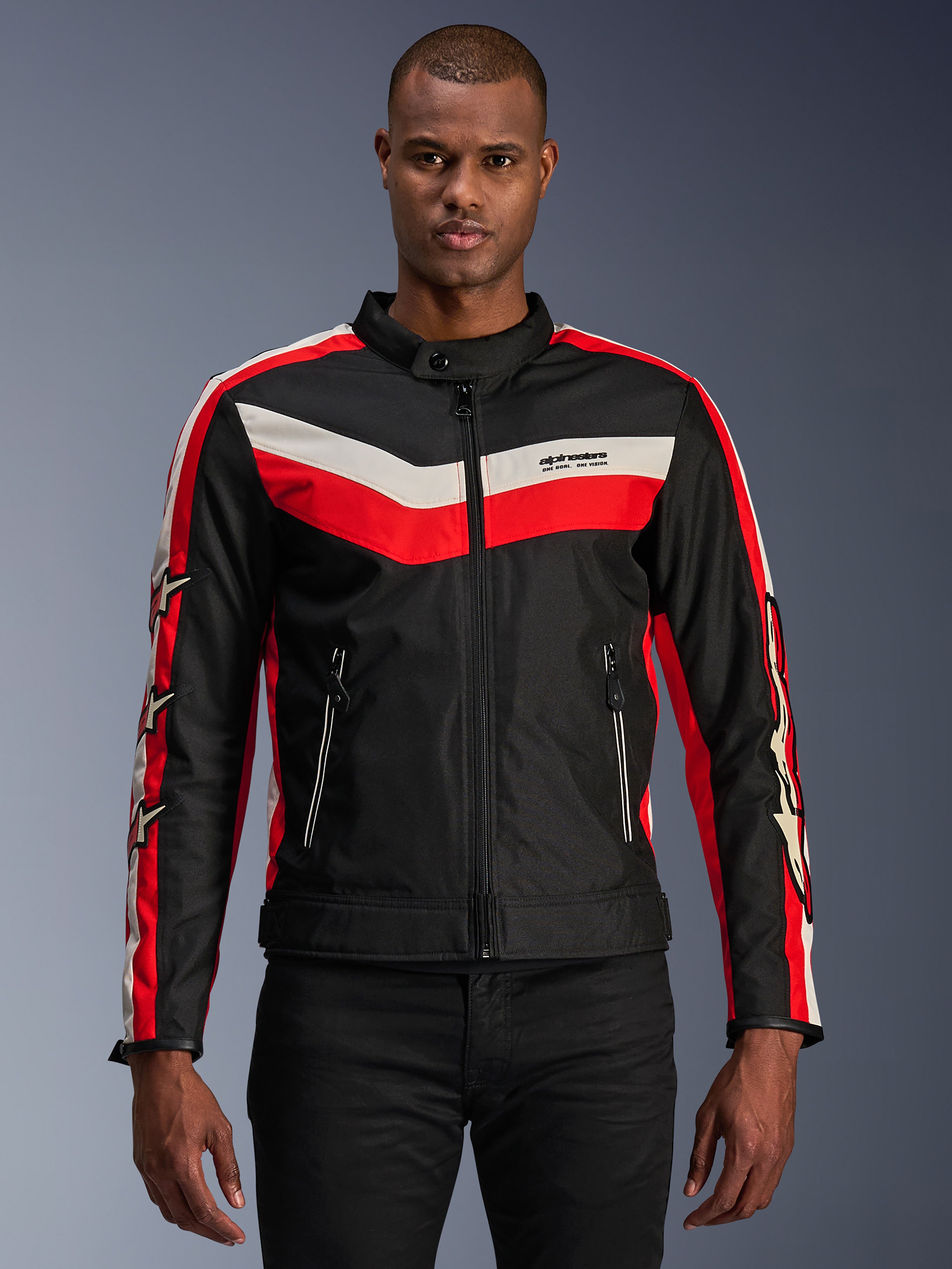 Alpinestars T-Dyno WR Jacket, Textile Motorcycle Jacket, Black with Bright Red and Ecru Chevron Stripes, vintage-inspired biker fit, high collar with button closure, zippered front pockets, star logos on sleeves, worn by model