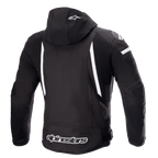 Alpinestars Zaca vandtæt jakke, motorcykeljakke, sort og hvid, set bagfra viser aftagelig hætte med hvidt stjernelogo, vertikale hvide striber på ryggen, Alpinestars-branding på den nederste kant og ribbede strækpaneler for bevægelighed
