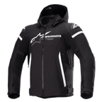 Alpinestars Zaca vandtæt jakke, sort motorcykeljakke med aftagelig hætte, stort hvidt Alpinestars-logo på brystet, hvide striber på overarmene og lodrette sideaccenter, lynlås foran, forstærket skulderbeskyttelse, justerbare stropper i taljen og på armene, tekstil-softshellkonstruktion