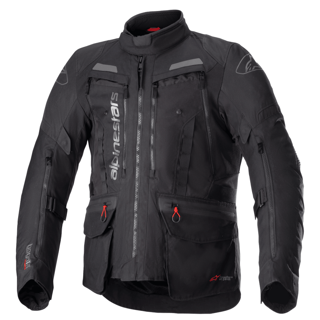 Alpinestars Bogota Pro Drystar jakke, helsort motorcykel touringjakke, grå og røde detaljer, store ventilationspaneler på brystet, vandtætte lommer med røde snoretræk, høj beskyttende krave, slidstærk tekstilkonstruktion til adventure-kørsel