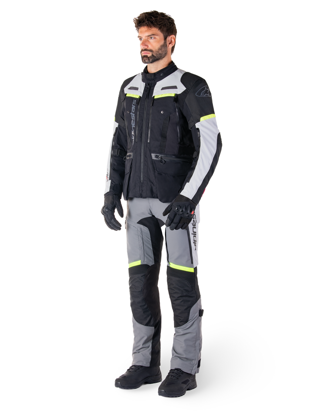 Alpinestars Bogotá Pro Drystar® jakke, adventure touring motorcykeljakke, Black Ice Gray Yellow Fluo, båret af model med matchende bukser og sorte handsker, med vandtæt tekstilkonstruktion, ventilationspaneler og fluorescerende detaljer.