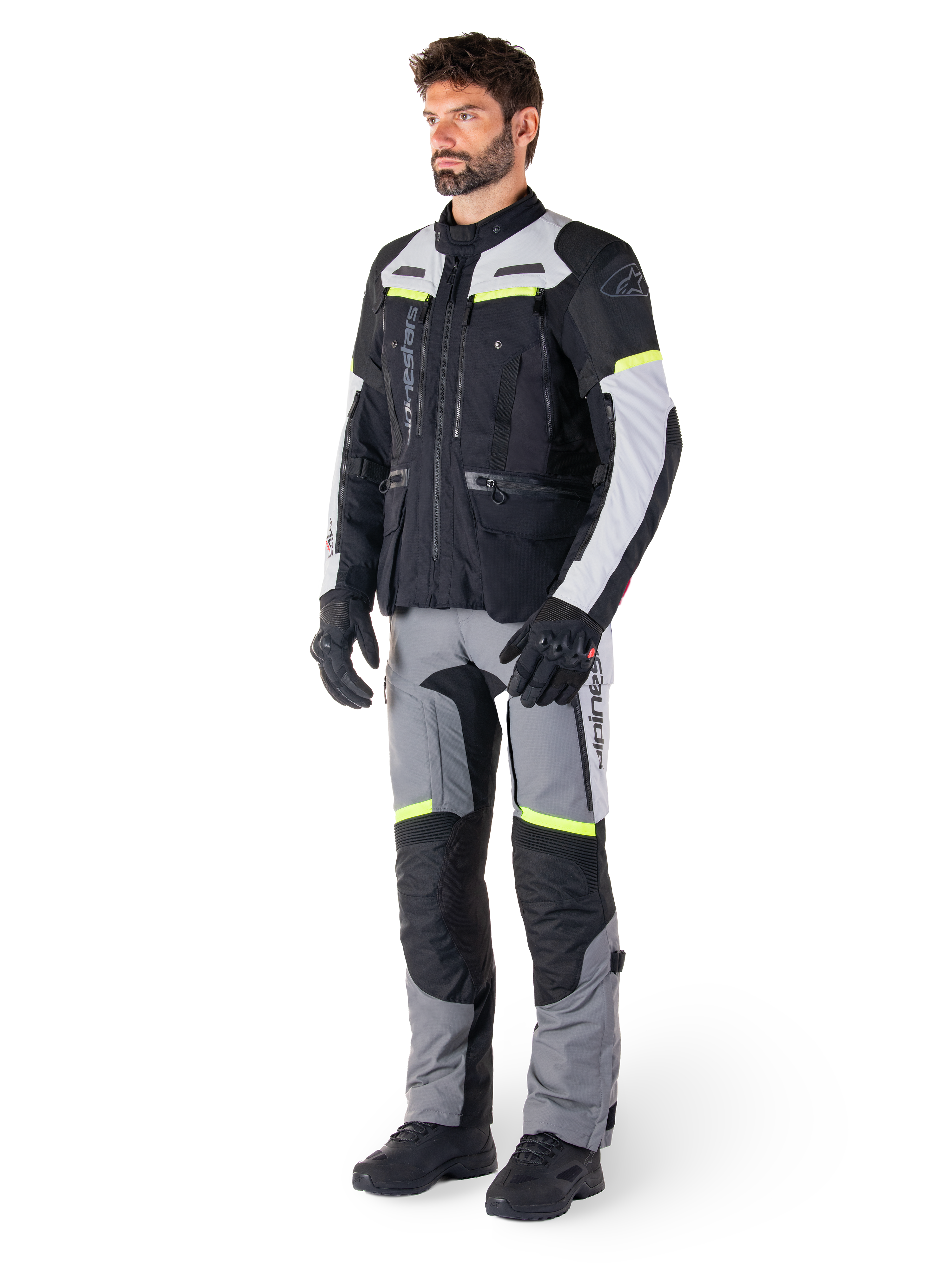 Alpinestars Bogotá Pro Drystar® jakke, adventure touring motorcykeljakke, Black Ice Gray Yellow Fluo, båret af model med matchende bukser og sorte handsker, med vandtæt tekstilkonstruktion, ventilationspaneler og fluorescerende detaljer.
