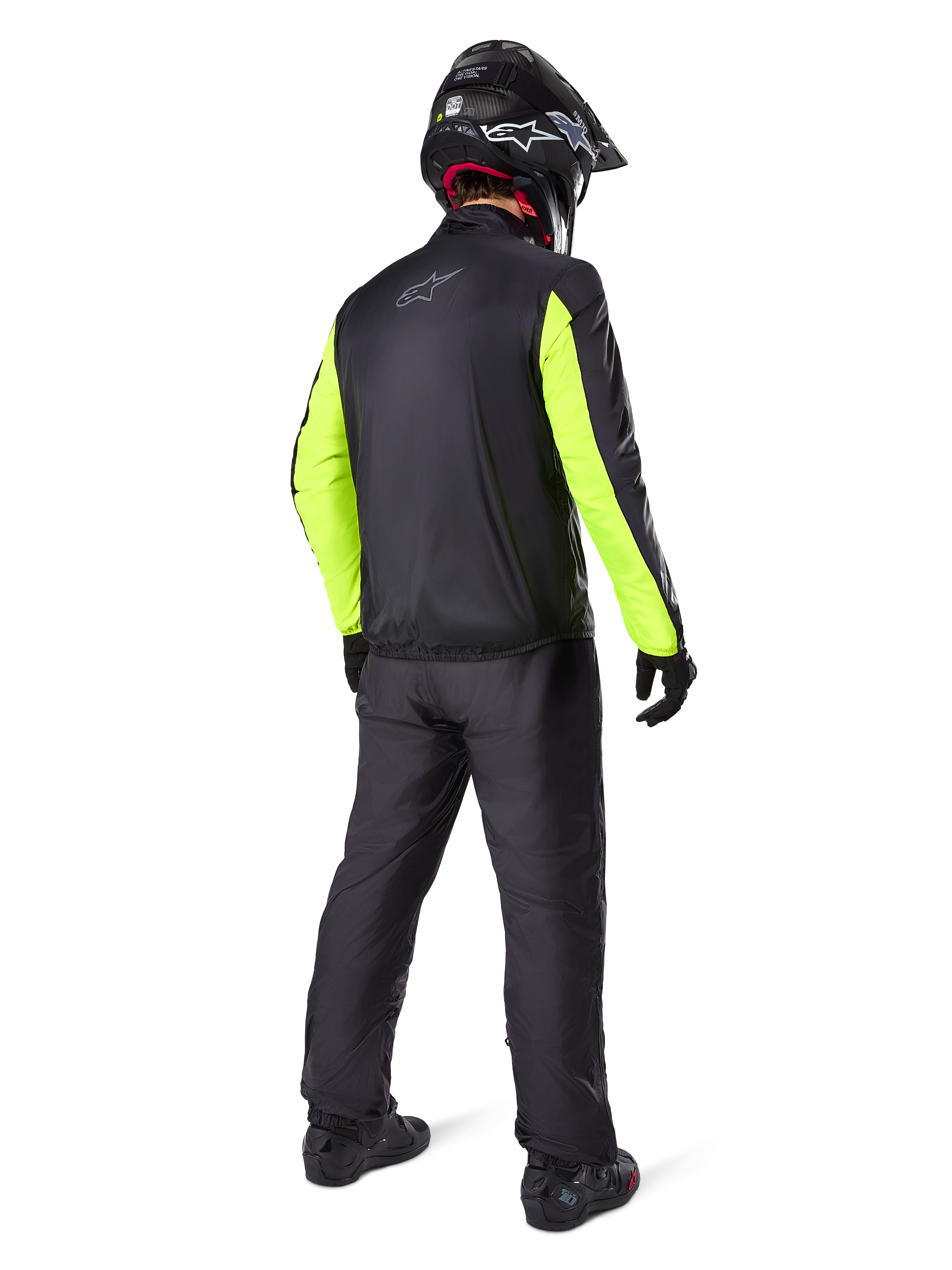 Motorcykelrytter set bagfra iført Alpinestars Bogotá Pro Drystar®-jakke, sort med klare Yellow Fluo-ærmer, matchende sorte bukser og hjelm, teknisk adventure-udstyr til helårsbrug