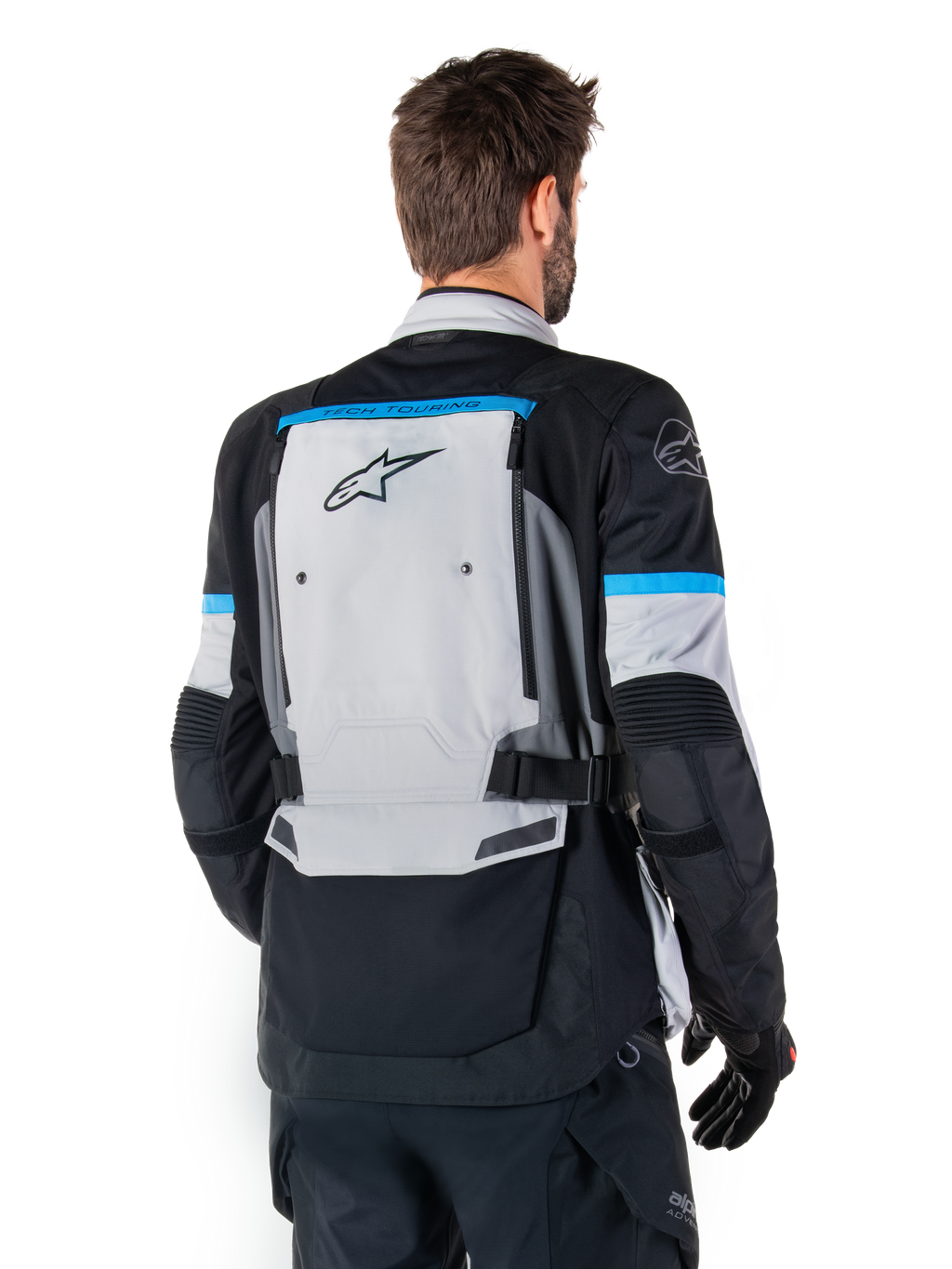 Alpinestars Bogota' Pro Drystar® Jakke, adventure-motorcykeljakke, isgrå, sort og cyan, set bagfra med fokus på det store grå rygpanel med Tech Touring-branding, cyan-accenter på ærmerne og holdbar tekstilkonstruktion.