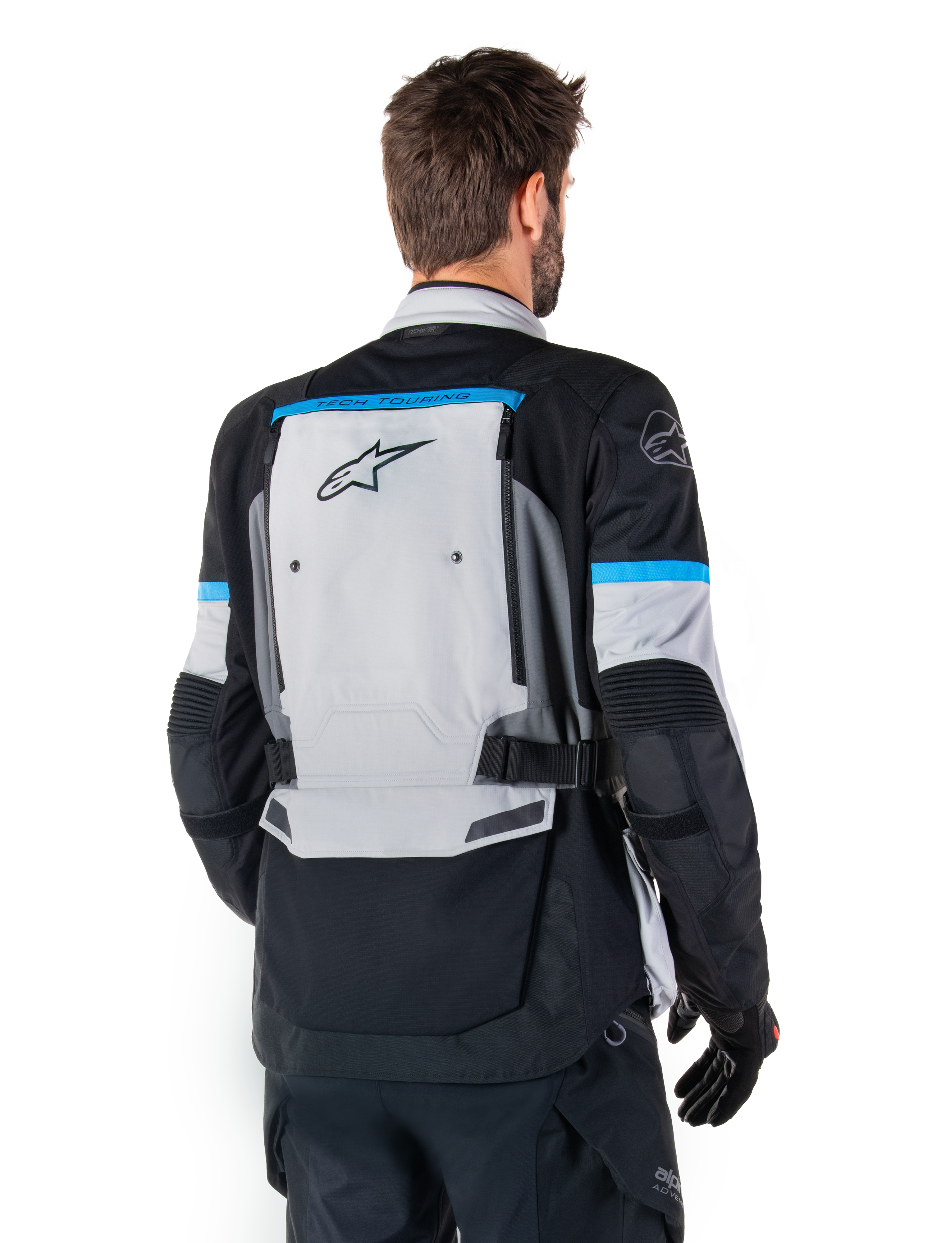 Alpinestars Bogota' Pro Drystar® Jakke, adventure-motorcykeljakke, isgrå, sort og cyan, set bagfra med fokus på det store grå rygpanel med Tech Touring-branding, cyan-accenter på ærmerne og holdbar tekstilkonstruktion.