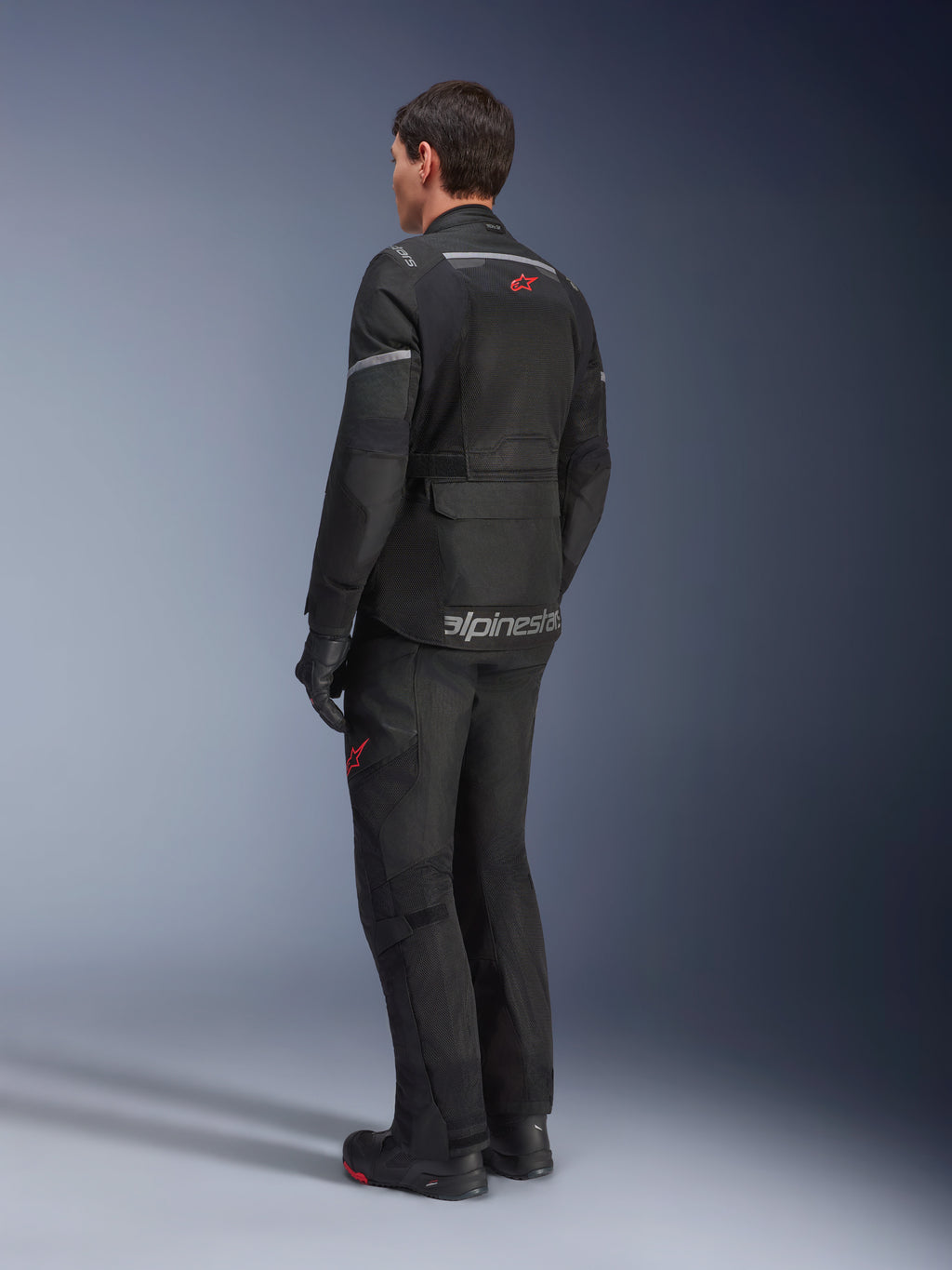 Alpinestars Andes Air Drystar® Pants and matching jacket, Black with red star logos, adventure touring motorcycle gear shown from the back, featuring mesh ventilation panels and reflective details.