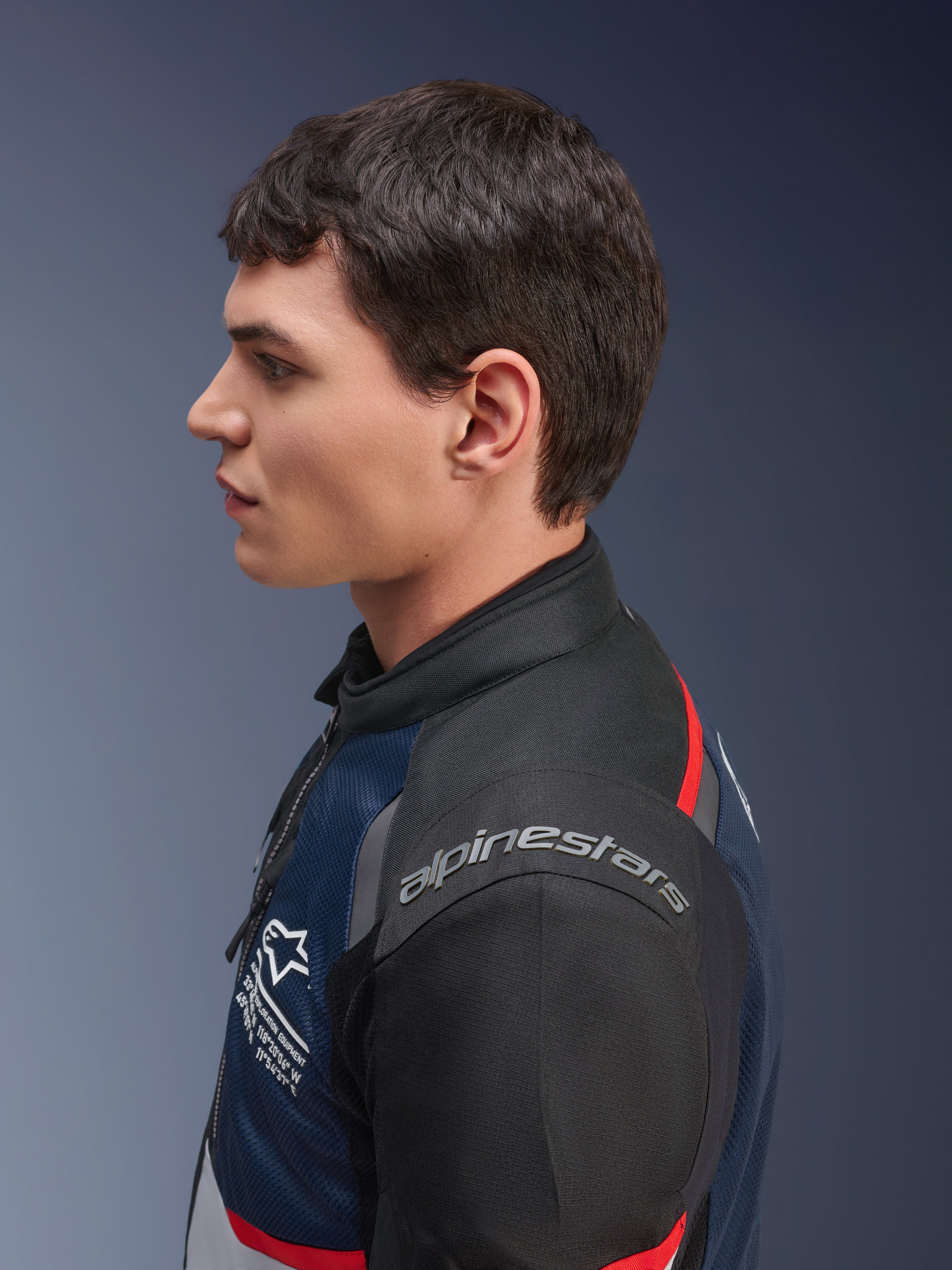 Alpinestars Andes Air Drystar®-jakke, Deep Blue Black Ice Gray-farvekombination, sideprofil af en mandlig model iført tekstiljakken i mesh, med Alpinestars-branding på skulderen og røde detaljer, touringudstyr til to sæsoner