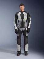 Alpinestars Andes Air Drystar® jakke i Ice Gray, Dark Gray og sort, båret af en mandlig model med matchende kørebukser og handsker, adventure touring-design med store forlommer og fluorescerende gule detaljer, set forfra i studiet