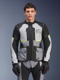 Mandlig kører iført Alpinestars Andes Air Drystar®-jakke i Ice Gray, Dark Gray og sort, med neongule detaljer og mesh-ventilationspaneler, kombineret med matchende motorcykelbukser og handsker, adventure touring-udstyr