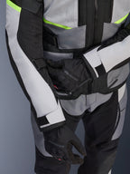Alpinestars Andes Air Drystar® jakke, touring-motorcykeljakke, Ice Gray og Dark Gray med neon-gule detaljer, tætbillede der viser mesh-paneler og justeringsstropper, bæres med sorte Alpinestars-handsker