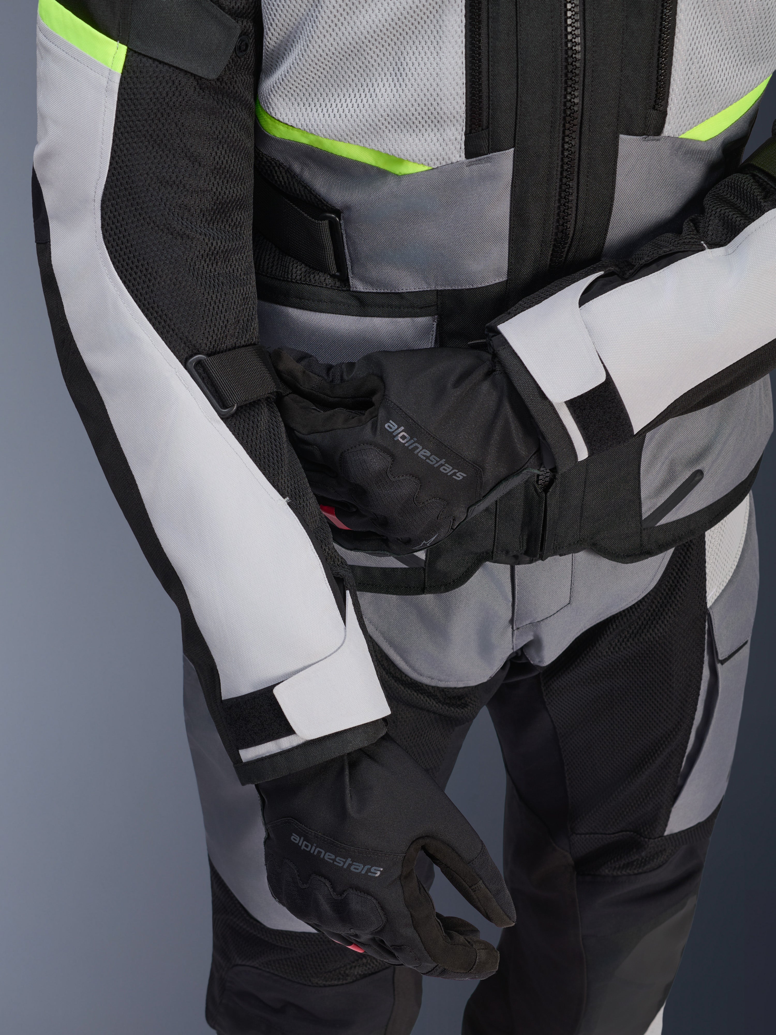 Alpinestars Andes Air Drystar® jakke, touring-motorcykeljakke, Ice Gray og Dark Gray med neon-gule detaljer, tætbillede der viser mesh-paneler og justeringsstropper, bæres med sorte Alpinestars-handsker