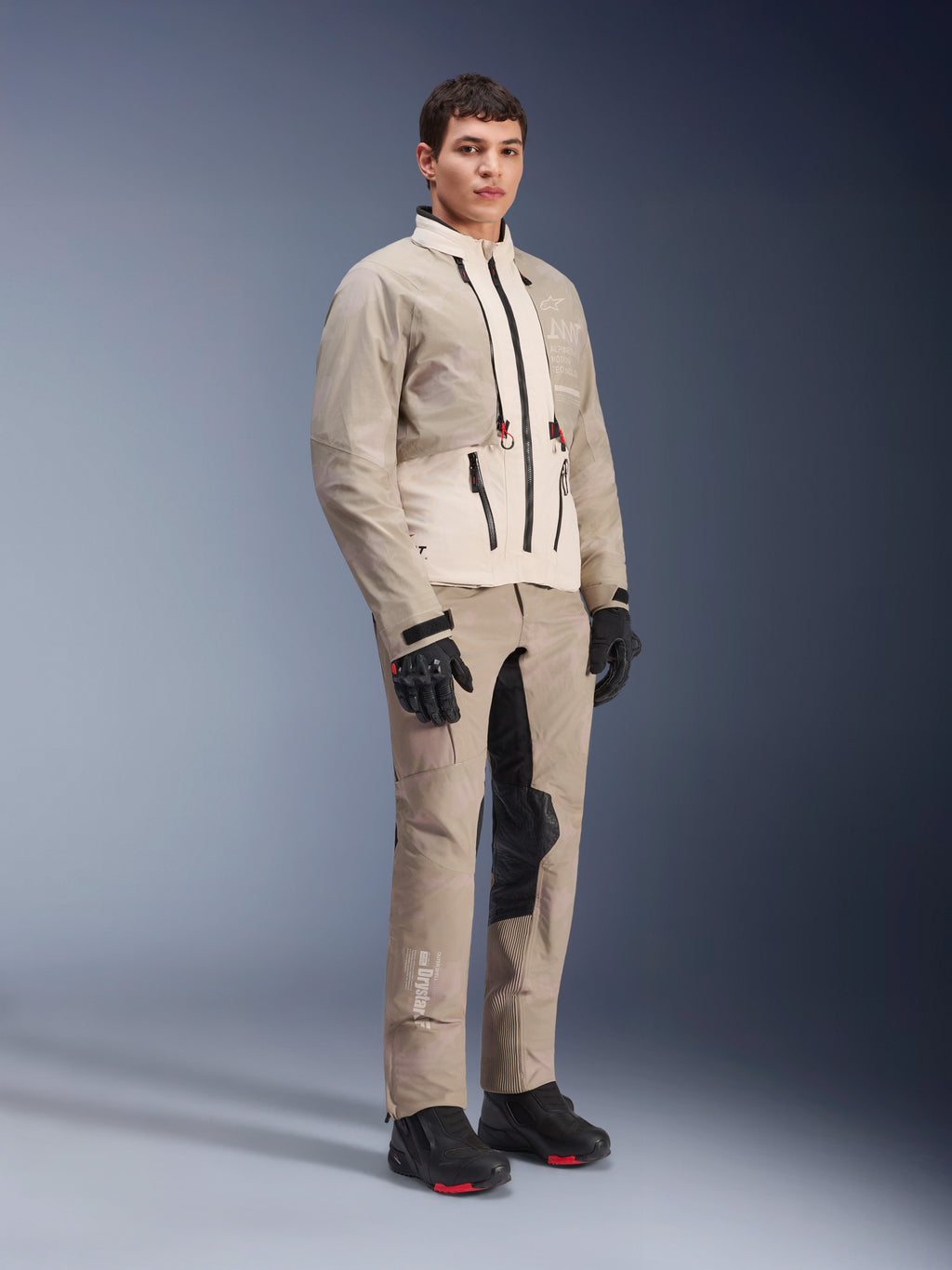 Alpinestars AMT-10LAB Drystar® XF-bukser og matchende jakke, Aluminum Camo adventure-køreudstyr, komplet outfit med sorte handsker og støvler, med teknisk branding og modulære beskyttelsespaneler, studio lifestyle-billede