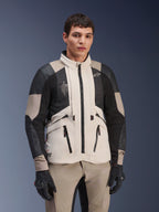 Alpinestars AMT-10LAB Drystar® XF jakke, White Sand Aluminum Camo, motorcykel adventure-jakke med sorte MATRYX® mesh-paneler og læderforstærkninger, båret af en model med sorte handsker og matchende sandfarvede bukser, studioportræt