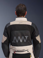 Bagfra-visning af Alpinestars AMT-10LAB Drystar® XF-jakke i White Sand og sort, med et stort AMT-logo på rygpanelet i mesh, Alpinestars-branding på den nederste del af ryggen og teknisk tekstilkonstruktion til adventure-motorcykelkørsel