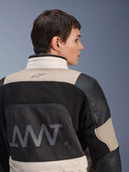 Alpinestars AMT-10LAB Drystar® XF jakke, set bagfra på mandlig model, White Sand Aluminum Camo og sort farvekombination, med stort AMT-logo, ventilationspaneler i mesh og læderforstærkninger, teknisk adventure-motorcykelbeklædning