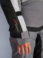 Alpinestars Stella Andes V4 Drystar® jakke, dame-ærme i grå tekstil med logo og velcrolukning ved håndleddet.