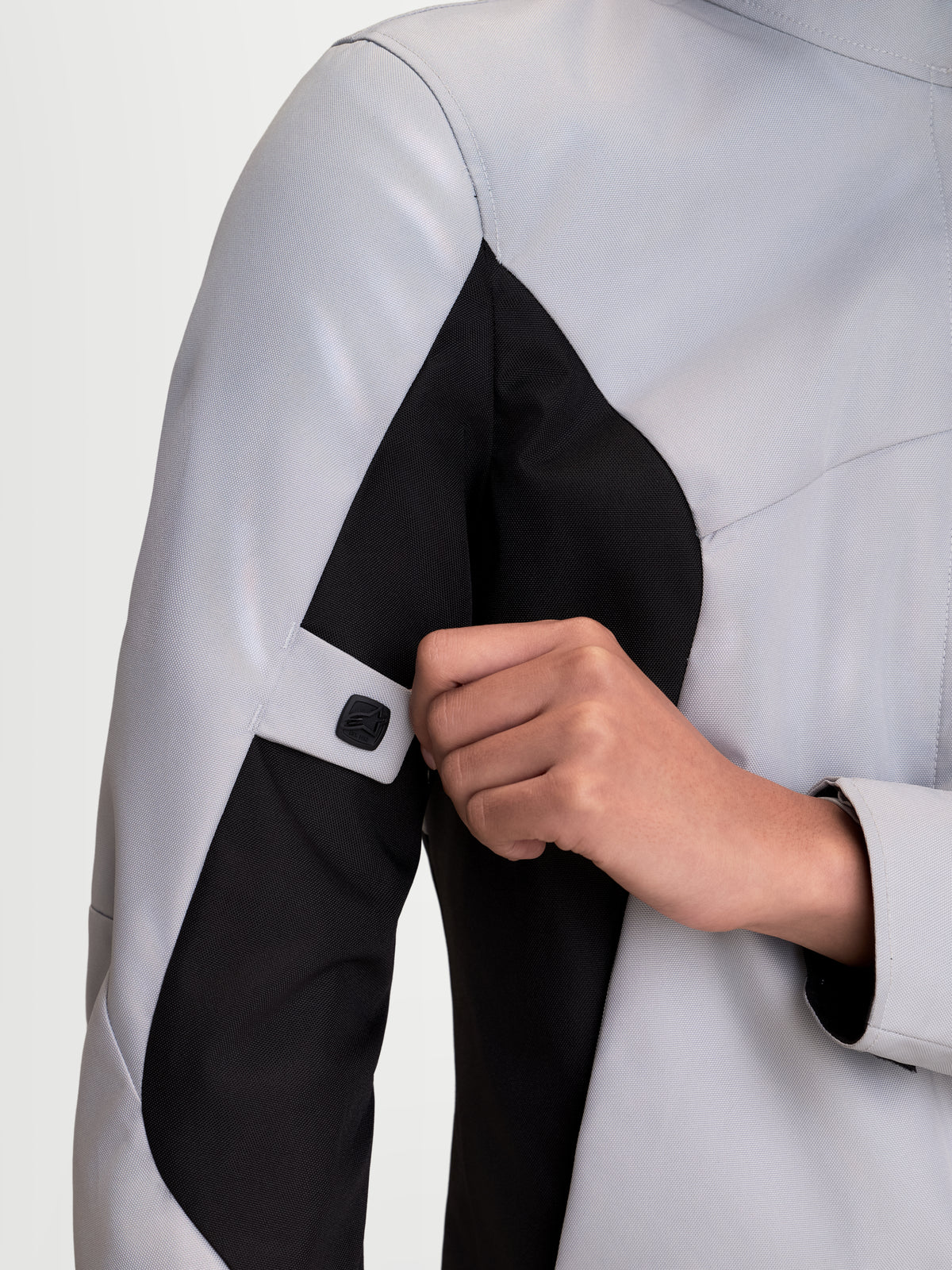 Alpinestars Stella C-1 Waterproof Jacket, women's urban motorcycle textile jacket, ice gray and black, close-up view of arm adjustment strap and ergonomic sleeve construction