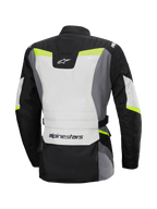 Alpinestars Stella ST-1 vandtæt jakke, set bagfra, motorcykel touring-jakke til kvinder, Ice Gray, sort og gul fluo, har Alpinestars-logo på lænden og nakken, adventure touring-design med beskyttende tekstilkonstruktion og fluorescerende detaljer.
