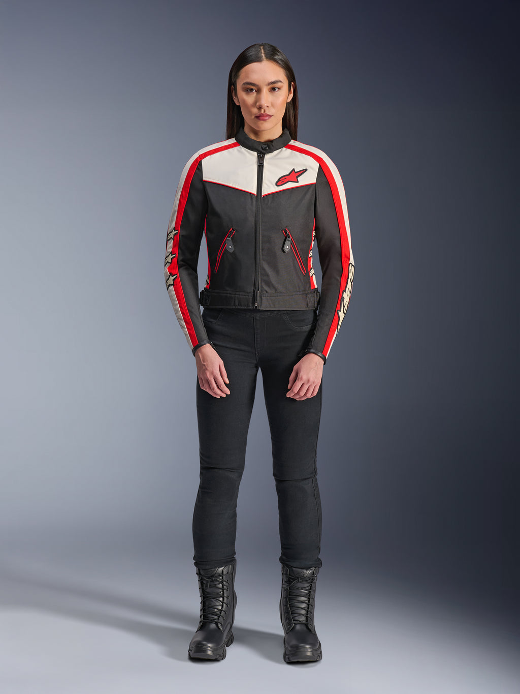 Alpinestars Stella T-Dyno WR-jakke, tekstilmotorcykeljakke til kvinder, sort, ecru og klar rød, bæres af model med sorte bukser og støvler, vintage-inspireret design med rødt Alpinestars-logo og kontrastpaneler