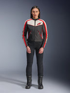 Alpinestars Stella T-Dyno WR-jakke, tekstilmotorcykeljakke til kvinder, sort, ecru og klar rød, bæres af model med sorte bukser og støvler, vintage-inspireret design med rødt Alpinestars-logo og kontrastpaneler