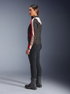 Alpinestars Stella T-Dyno WR Jakke, tekstilmotorcykeljakke til kvinder, sort, ecru og lys rød, med vintage-inspireret design og Astars-branding på ærmet, båret med tætsiddende sorte bukser og sorte støvler, kortere biker-pasform til urban kørsel