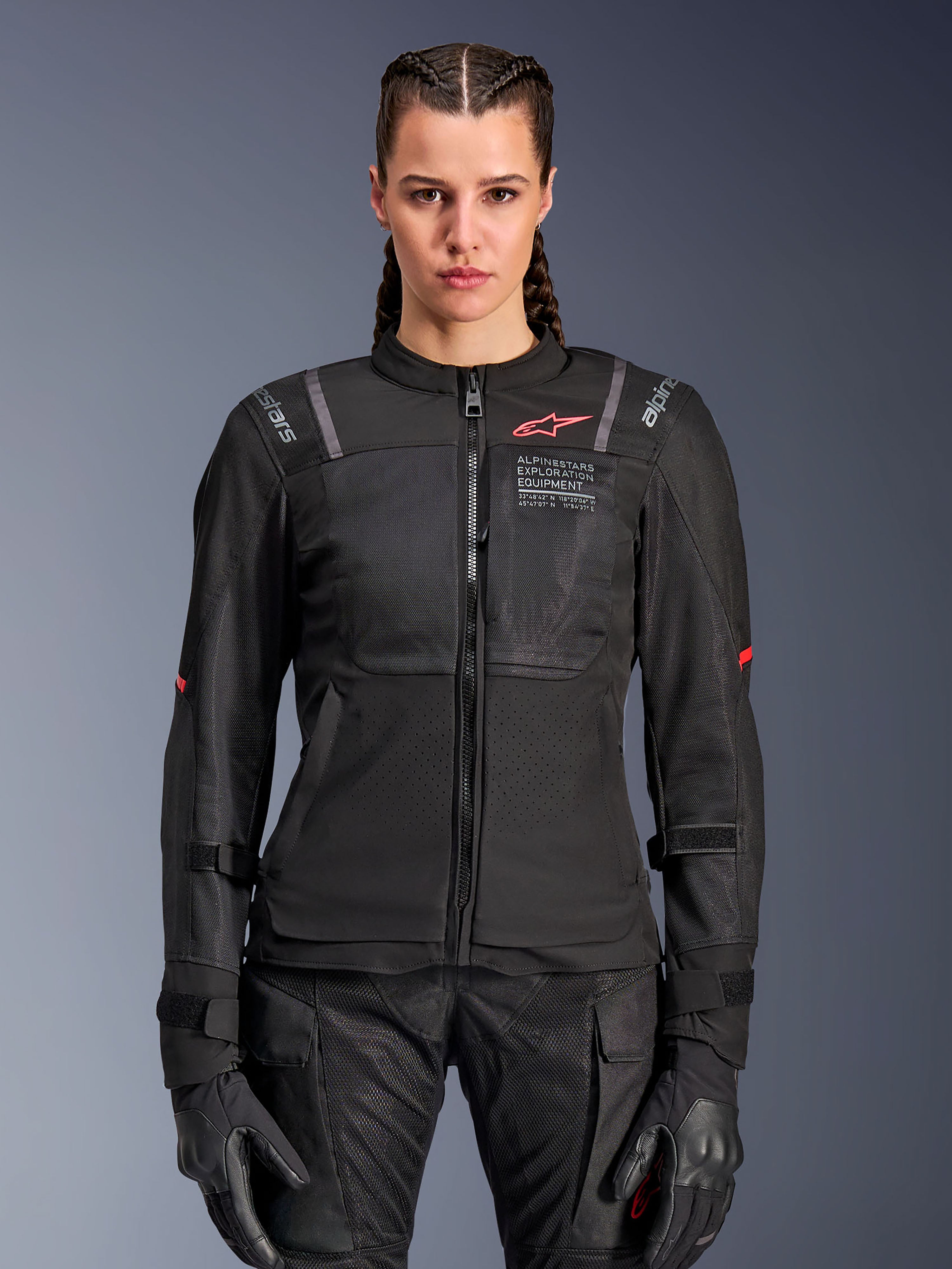 Alpinestars Stella ST-2 Air jakke til damer, motorcykeljakke til kvinder, sort, set forfra på model, med mesh-paneler, rødt logo på brystet og Alpinestars Exploration Equipment-branding, båret med sorte handsker og kørebukser.