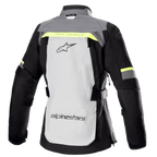 Alpinestars Stella Bogotá Pro Drystar® damejakke, set bagfra, isgrå og mørkegrå med fluorescerende gule detaljer, stort logo på ryggen, 'Tech Touring'-tekst, lodrette ventilationslynlåse og forstærkede harmonika-paneler på albuerne.