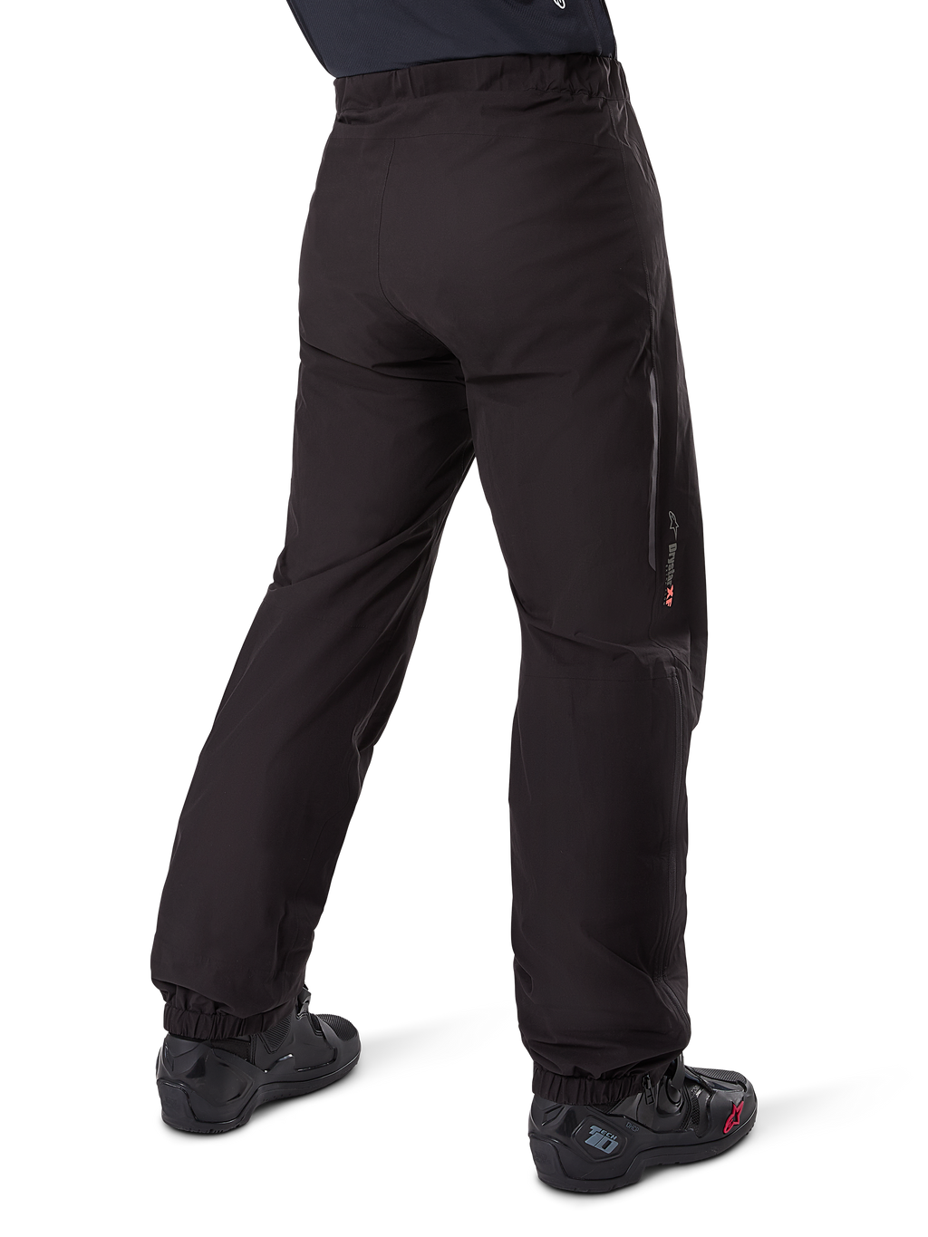 Alpinestars Amt-8 Stretch Drystar® XF Pant Liner, sort, set bagfra, viser den vandtætte liner båret over sorte motorcykelstøvler, med Drystar XF-branding på underbenet, elastiske ankelmanchetter og letvægtsstrækmateriale til adventure touring.