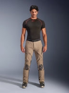 Mandlig model iført Alpinestars AMT-8 Stretch Drystar® XF bukser i Walnut og sort, kombineret med et sort kortærmet basislag, adventure touring-bukser med forstærkede knæ, lynlåslukket ventilation og ergonomisk strækdesign.