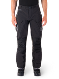 Alpinestars Hyde XT Drystar bukser, sorte adventure touring-bukser, båret af en kører med sorte støvler, med grå logoer på lårene, integreret bælte, forstærkede knæpaneler og vandtæt tekstilkonstruktion.
